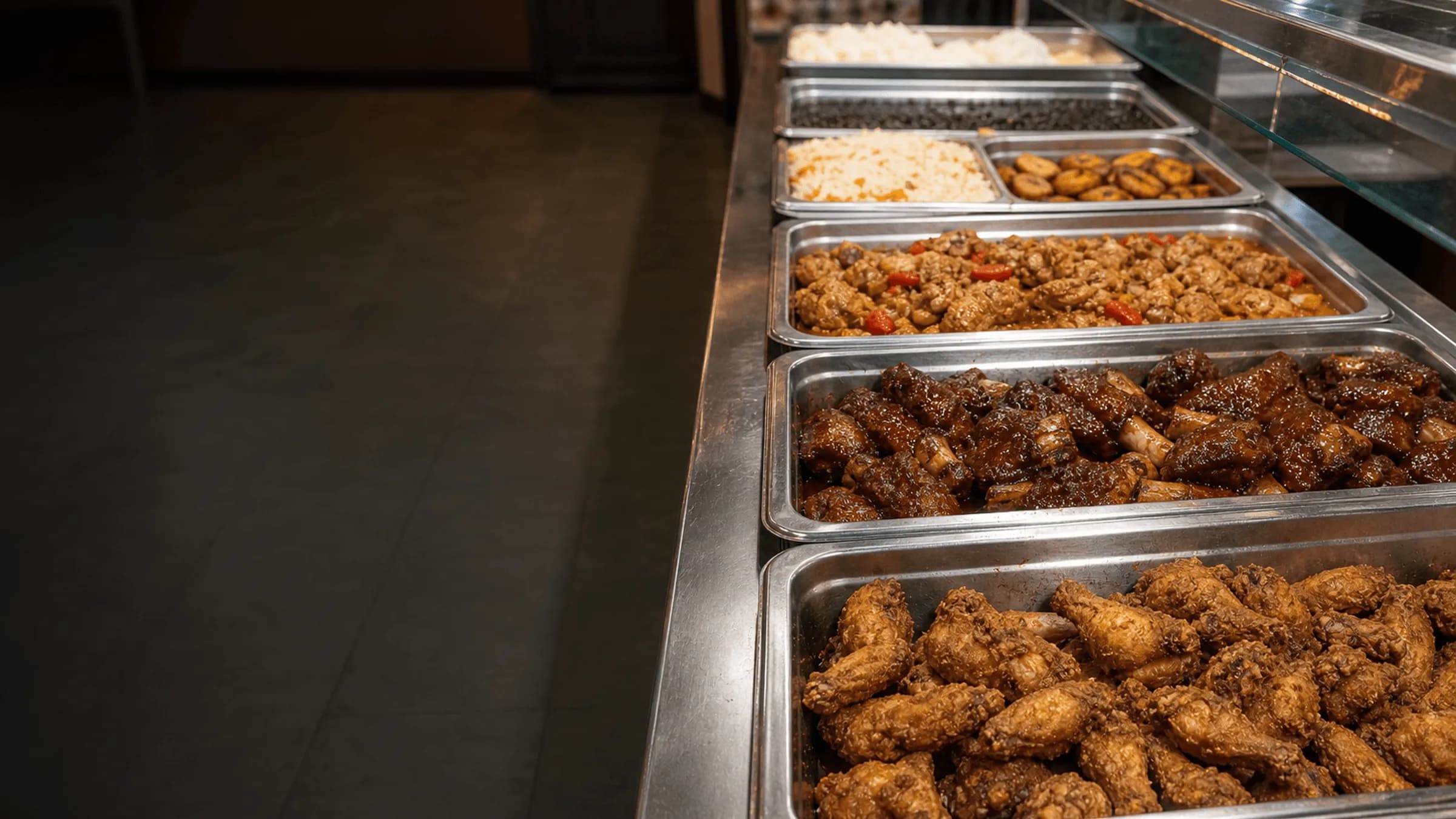 Barra de buffet de Buffet Latino BBQ con pollo frito, costillas BBQ, guiso, arroz, caraotas y platanos